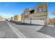 Row of townhomes featuring attached garages and neutral exteriors on a sunny day at 6320 Desert Leaf St # 101, North Las Vegas, NV 89081