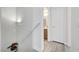 Hallway with white trim, hardwood floors, a handrail, and a doorway leading to a bathroom at 6320 Desert Leaf St # 101, North Las Vegas, NV 89081