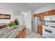 Kitchen with stainless steel fridge, granite countertop island, and white appliances at 6320 Desert Leaf St # 101, North Las Vegas, NV 89081