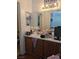 Bathroom vanity with wood cabinets, mirror, sink, and modern lighting fixture at 6380 Extreme Shear Ave # 102, Henderson, NV 89011