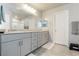 Bathroom featuring double vanity, gray cabinetry, granite counters, and a large mirror at 7322 Glimmer Point St, North Las Vegas, NV 89084