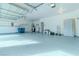 Spacious three-car garage featuring epoxy flooring, ample shelving, and overhead lighting, perfect for storage and projects at 9824 Gallo Dr, Las Vegas, NV 89147