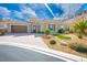 Attractive home showcasing desert landscaping, stone accents, a putting green, and a brick driveway at 1 Grand Masters Dr, Las Vegas, NV 89141