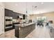 Modern kitchen featuring dark cabinetry, a tile backsplash, granite countertops, and stainless steel appliances at 1 Grand Masters Dr, Las Vegas, NV 89141