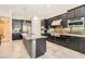 Modern kitchen with stainless steel appliances, dark cabinetry, island with mosaic accents, and tile flooring at 1 Grand Masters Dr, Las Vegas, NV 89141