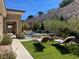 Relaxing backyard with a pool, lounge chairs, and green lawn, with a rock wall for privacy at 1 Grand Masters Dr, Las Vegas, NV 89141