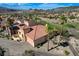 An aerial view showing the beautiful desert landscape and house with solar panels in a golf community at 1150 Calcione Dr, Henderson, NV 89011