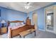 Charming bedroom with blue walls, wood furniture, an ensuite bathroom, and a ceiling fan at 1150 Calcione Dr, Henderson, NV 89011