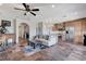 Open-concept living room with stone flooring, modern lighting, and views of the adjacent kitchen at 1150 Calcione Dr, Henderson, NV 89011