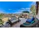 Outdoor patio with wicker seating, mountain views, an umbrella covered table and desert landscaping at 1150 Calcione Dr, Henderson, NV 89011