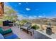 An outdoor patio with seating, BBQ, desert landscaping and views of the surrounding mountains at 1150 Calcione Dr, Henderson, NV 89011