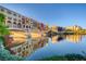 Charming waterfront buildings reflected on a tranquil lake under a clear sky at 1150 Calcione Dr, Henderson, NV 89011