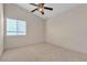 Well-lit bedroom with a ceiling fan, neutral carpet, and a window providing natural light at 1709 Guthrie Dr, Las Vegas, NV 89117