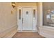 Close-up of a white front door with decorative glass panels and a stylish exterior light fixture at 1709 Guthrie Dr, Las Vegas, NV 89117