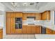 Functional kitchen with wooden cabinets, black appliances, and white tile countertops at 1709 Guthrie Dr, Las Vegas, NV 89117