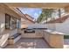 A built-in outdoor kitchen with a granite counter, grill, sink, and a seating bench at 1709 Guthrie Dr, Las Vegas, NV 89117