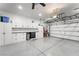 Clean and organized three-car garage with white cabinets, epoxy floor, and overhead storage racks at 181 Sierra Alta Pl, Henderson, NV 89015