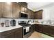 Modern kitchen featuring stainless steel appliances, white countertops, and dark wood cabinetry at 181 Sierra Alta Pl, Henderson, NV 89015