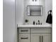 Modern powder room with white cabinets, black hardware, a vessel sink, and a framed mirror at 2004 Burnham Ave, Las Vegas, NV 89104