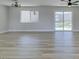 Bright living room with wood-look floors, modern lighting, and sliding glass doors to the backyard at 2004 Burnham Ave, Las Vegas, NV 89104