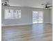 Bright living room with wood-look floors, modern lighting, and sliding glass doors to the backyard at 2004 Burnham Ave, Las Vegas, NV 89104