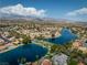 An aerial view showcasing a residential community nestled by a serene lake with mountain views at 2504 Cove Rd, Las Vegas, NV 89128