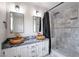 Bathroom with dual wooden bowl sinks, marble countertop, and tiled walk-in shower at 2504 Cove Rd, Las Vegas, NV 89128