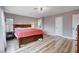 This primary bedroom has hardwood flooring and a king-size bed with a red comforter at 2504 Cove Rd, Las Vegas, NV 89128