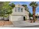 Inviting two-story home with attached two car garage, complimented by palm trees at 2504 Cove Rd, Las Vegas, NV 89128