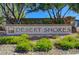 Community sign for Desert Shores featuring lush landscaping and a stone facade at 2504 Cove Rd, Las Vegas, NV 89128