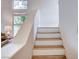 Staircase with wood and white risers and abundant natural light coming from the windows at 2504 Cove Rd, Las Vegas, NV 89128