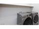 Bright laundry room with front loading washer and dryer and plenty of shelving at 26 Lilla Rosa St, Henderson, NV 89011