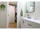 Bright bathroom featuring a white vanity with a black faucet, a modern mirror, and a glimpse into the walk-in closet at 306 Rodarte St, Henderson, NV 89014