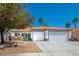 Single-story home featuring a two-car garage, tile roof, neutral paint and rock landscaping at 306 Rodarte St, Henderson, NV 89014