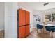 Modern kitchen with sleek, white cabinets and an eye-catching orange refrigerator at 306 Rodarte St, Henderson, NV 89014