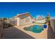 Backyard view of a kidney-shaped pool and patio, artificial grass, and an exterior view of the home at 4032 Rustic Oak Ct, North Las Vegas, NV 89032