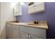 Bathroom featuring double sinks, cabinets, and a purple accent wall at 4032 Rustic Oak Ct, North Las Vegas, NV 89032