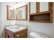 Bathroom features an oak vanity, decorative mirror, and a toilet at 4032 Rustic Oak Ct, North Las Vegas, NV 89032