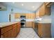 Bright kitchen with stainless steel appliances, tile floors, light-colored wood cabinets and an island at 4032 Rustic Oak Ct, North Las Vegas, NV 89032