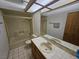 Bright bathroom featuring a shower-tub combo with glass doors, single sink vanity, and tiled floors at 4055 Nook Way # A, Las Vegas, NV 89103