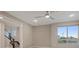 Comfortable bedroom featuring a ceiling fan, large window, and an open staircase nearby at 4288 Veraz St, Las Vegas, NV 89135