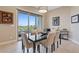 Contemporary dining room with glass table, six chairs, and sliding doors to outdoor patio at 4288 Veraz St, Las Vegas, NV 89135