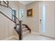 Staircase of a modern home featuring neutral tones, carpeted stairs and a white front door at 4288 Veraz St, Las Vegas, NV 89135