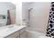 Bright bathroom features a tub, tiled shower, and a black and white shower curtain at 4421 Halbert Ave, Las Vegas, NV 89110