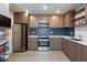 A modern kitchen with stainless steel appliances, wood cabinets, and a blue tile backsplash at 4421 Halbert Ave, Las Vegas, NV 89110