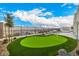 Scenic view of a backyard putting green, bordered by manicured landscaping and mature trees, offering privacy at 472 Sand Dune Arch St, Las Vegas, NV 89138