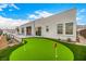 Modern home featuring a beautiful backyard with a lush green putting green and covered patio at 472 Sand Dune Arch St, Las Vegas, NV 89138