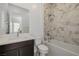 Bright bathroom features marble tiled shower and tub and a modern vanity at 472 Sand Dune Arch St, Las Vegas, NV 89138