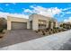 Contemporary single-story home showcasing a two-car garage, light brick facade, and manicured landscaping at 472 Sand Dune Arch St, Las Vegas, NV 89138