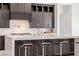 Kitchen island with seating, modern faucet, dark wood cabinets, and a white marble countertop at 472 Sand Dune Arch St, Las Vegas, NV 89138